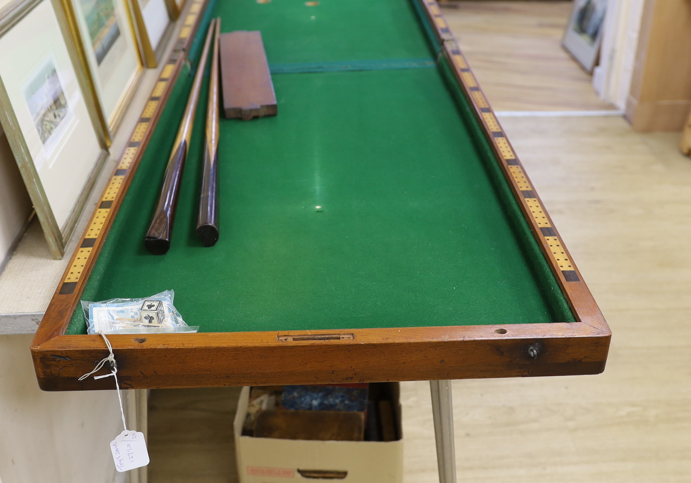 A Victorian folding cased bagatelle board, green baize interior with markers and two cues, 223.5cm open